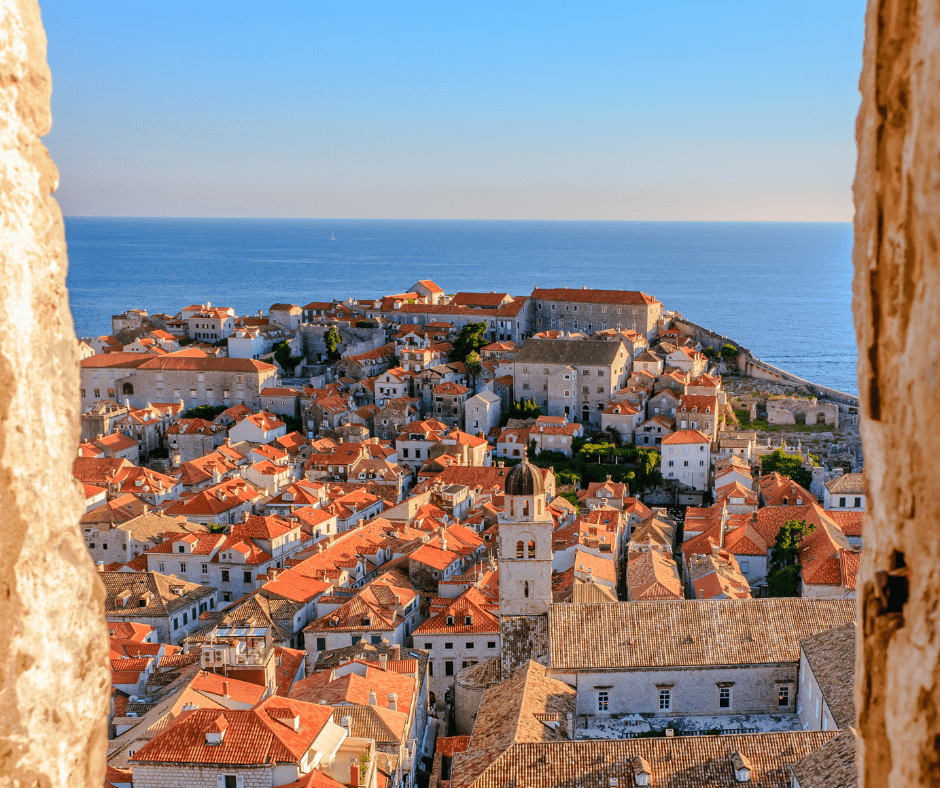 Panoramic view of Dubrovnik, Croatia, with its iconic terracotta rooftops, medieval city walls, and the Adriatic Sea in the background.