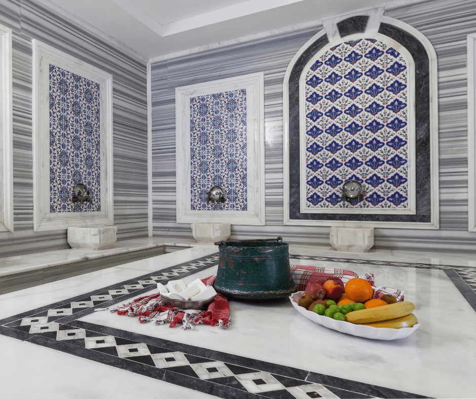 Interior of a historic Turkish bath (hamam) in Istanbul, featuring a central heated marble platform, arched ceilings, and soft ambient lighting.
