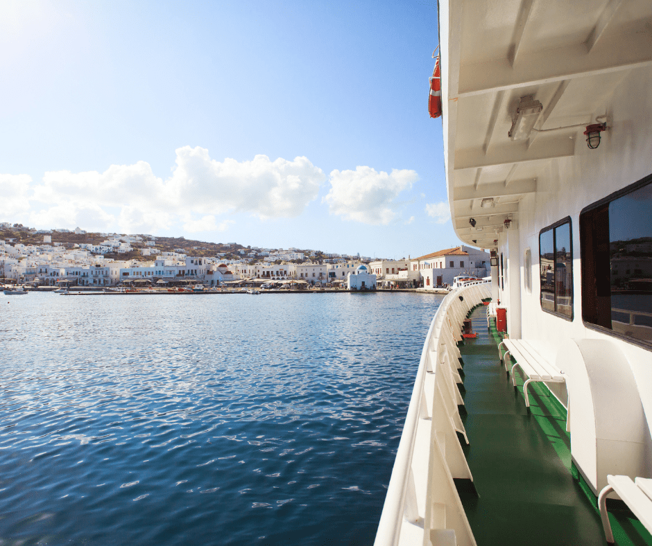 10 day Greece itinerary ferry ride to Mykonos with iconic Cycladic architecture and coastline in view