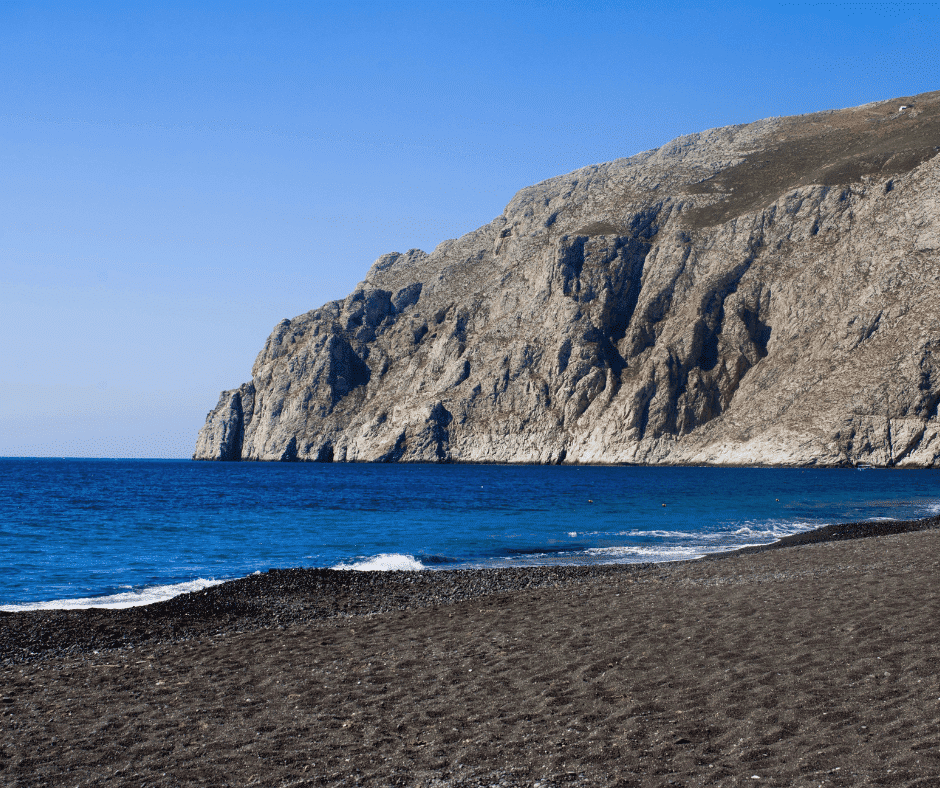 Unique beach experience on a 10 day Greece itinerary: Santorini’s black sand shoreline with calm Aegean waters and dramatic volcanic landscape